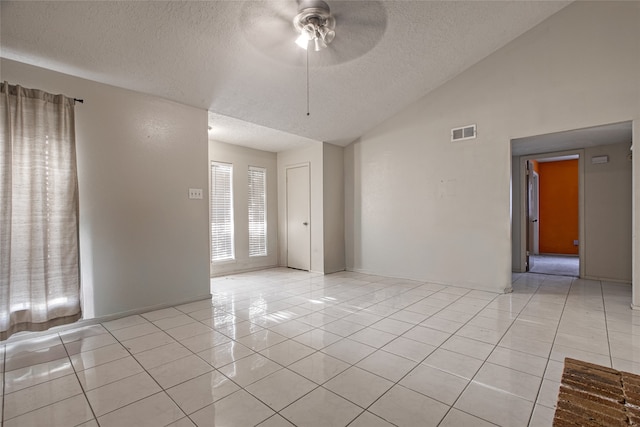 tiled spare room with a textured ceiling, ceiling fan, and lofted ceiling