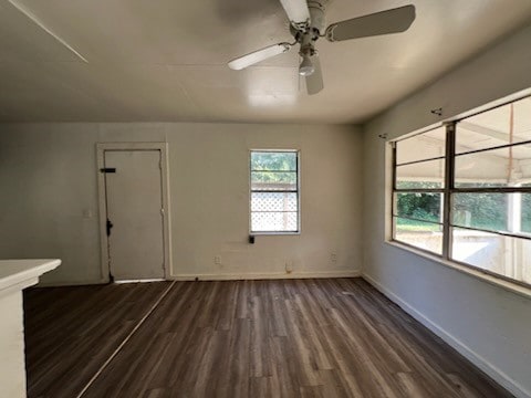 unfurnished room featuring dark wood-type flooring and ceiling fan