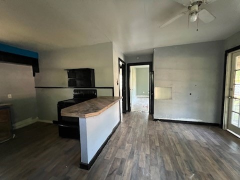 kitchen featuring black electric range, ceiling fan, a kitchen bar, and dark hardwood / wood-style floors