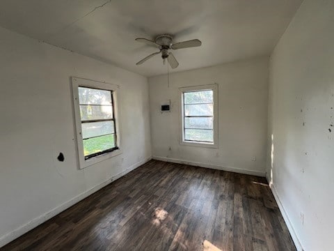 empty room featuring dark wood-type flooring, a wealth of natural light, and ceiling fan