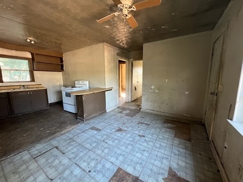 kitchen with ceiling fan, electric range, and sink