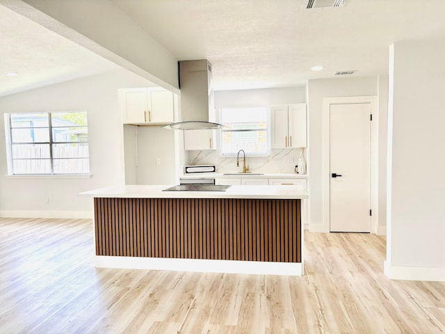 kitchen with plenty of natural light, a center island, and island range hood