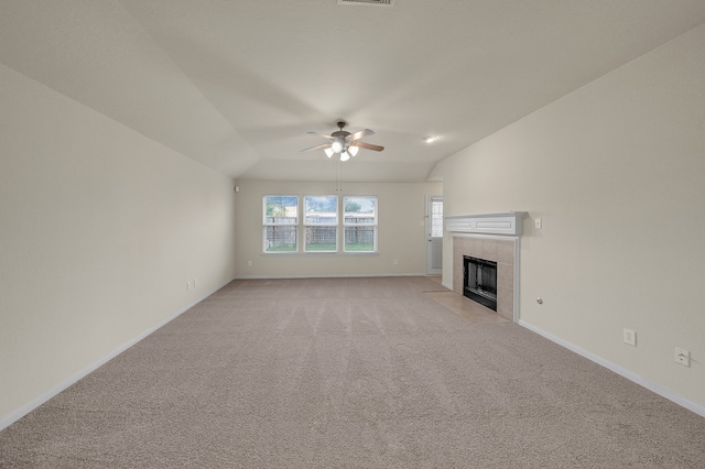 unfurnished living room featuring vaulted ceiling, light colored carpet, ceiling fan, and a tile fireplace