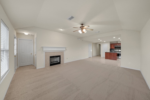 unfurnished living room featuring light colored carpet, a healthy amount of sunlight, and ceiling fan