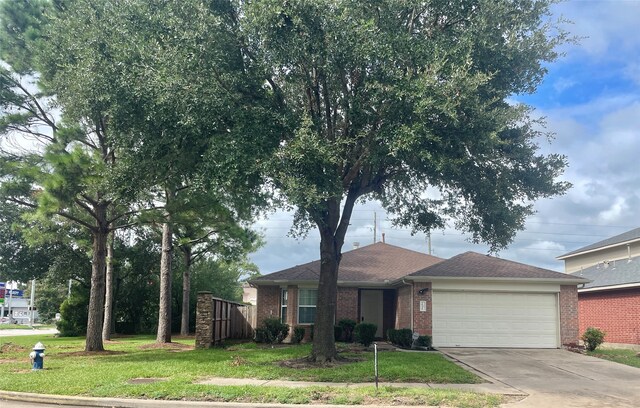 single story home with a garage and a front lawn