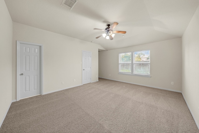 empty room with vaulted ceiling, light colored carpet, and ceiling fan