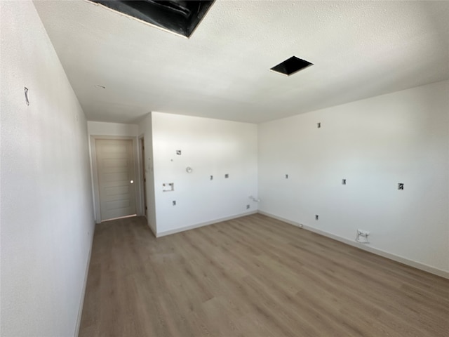 laundry room featuring a textured ceiling and hardwood / wood-style flooring