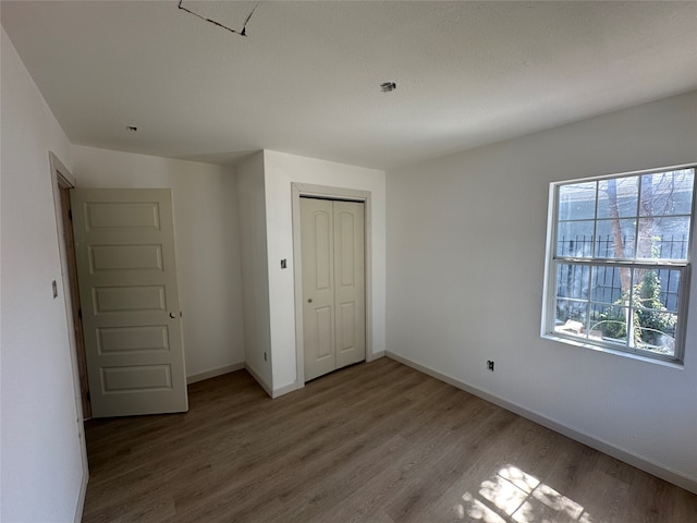 unfurnished bedroom with a closet and hardwood / wood-style floors