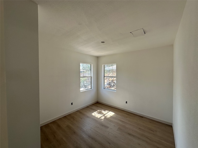 spare room with a textured ceiling and hardwood / wood-style flooring