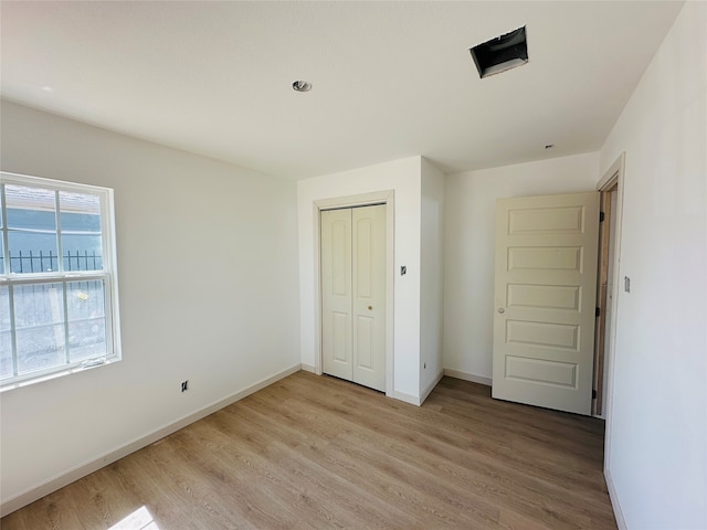 unfurnished bedroom featuring a closet and light wood-type flooring