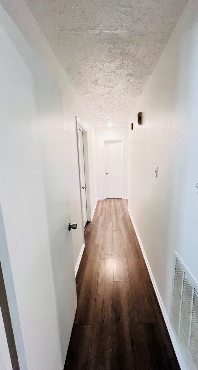 corridor featuring hardwood / wood-style floors and a textured ceiling