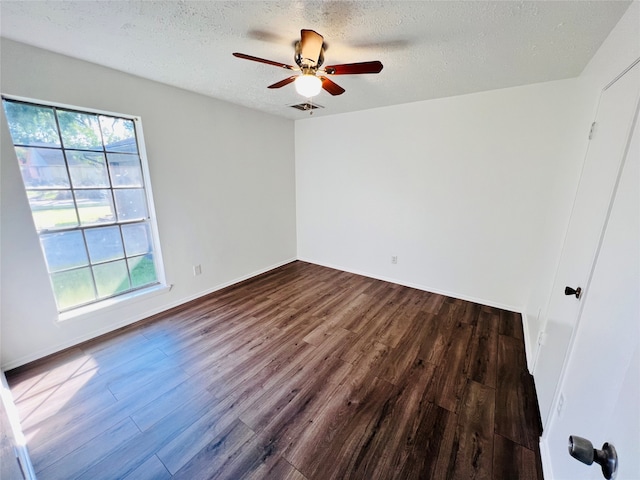 unfurnished room featuring a textured ceiling, a healthy amount of sunlight, ceiling fan, and dark wood-type flooring