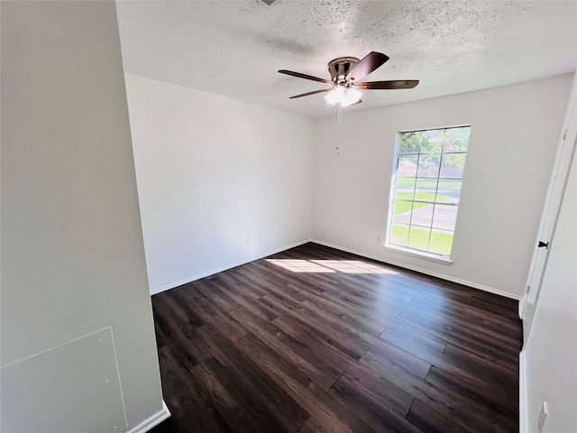 spare room featuring dark wood-type flooring, a textured ceiling, and ceiling fan