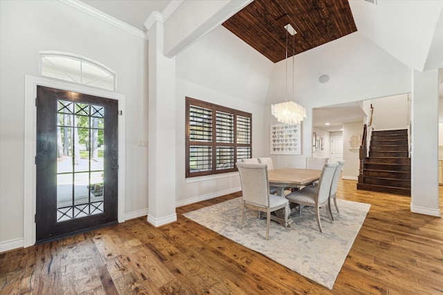 interior space featuring hardwood / wood-style floors, high vaulted ceiling, a chandelier, and ornamental molding