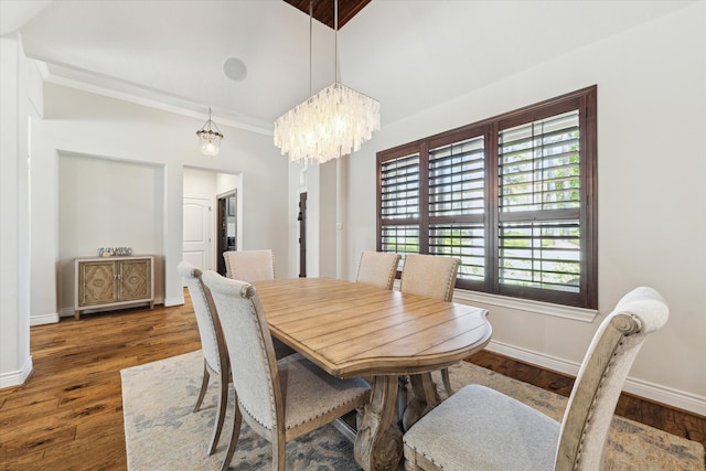 dining room featuring crown molding, vaulted ceiling, dark hardwood / wood-style floors, and a notable chandelier