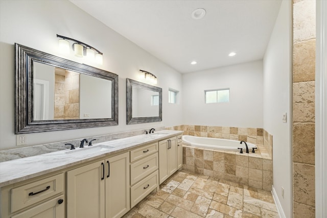 bathroom featuring vanity and tiled tub