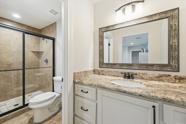 bathroom featuring vanity, toilet, and a shower with shower door