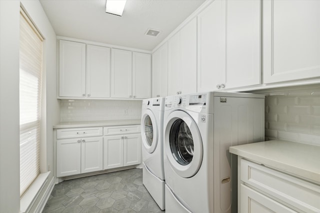 laundry room with light tile patterned floors, cabinets, and independent washer and dryer