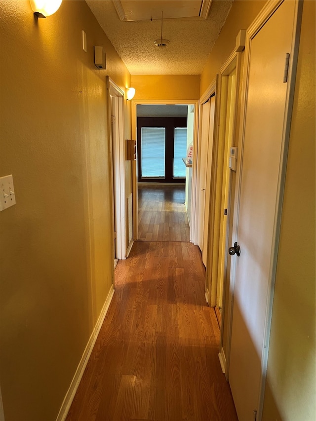 hall featuring hardwood / wood-style flooring and a textured ceiling