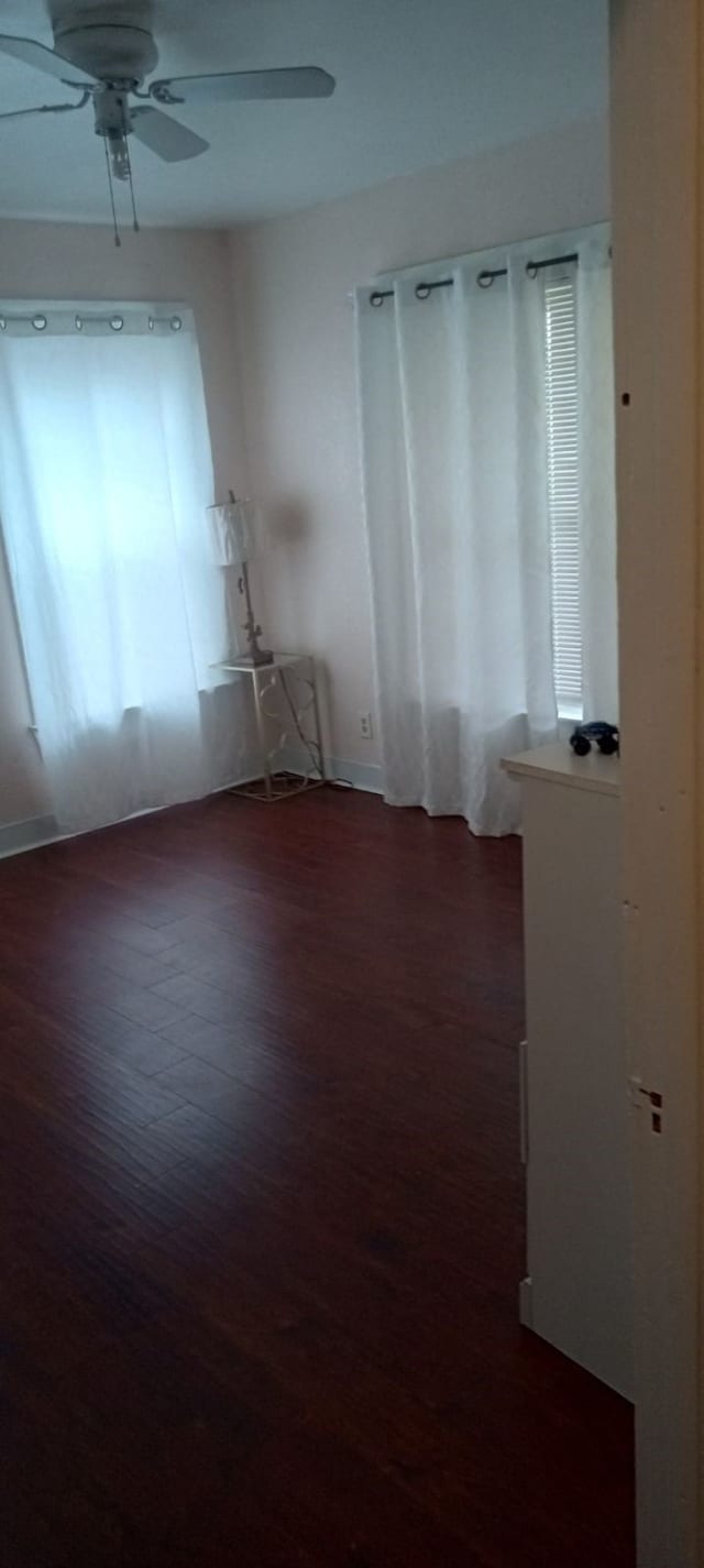 spare room featuring ceiling fan and dark hardwood / wood-style floors