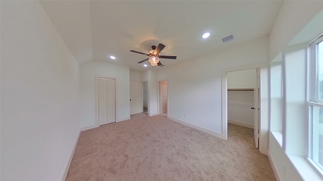 unfurnished bedroom with ceiling fan, light colored carpet, and vaulted ceiling