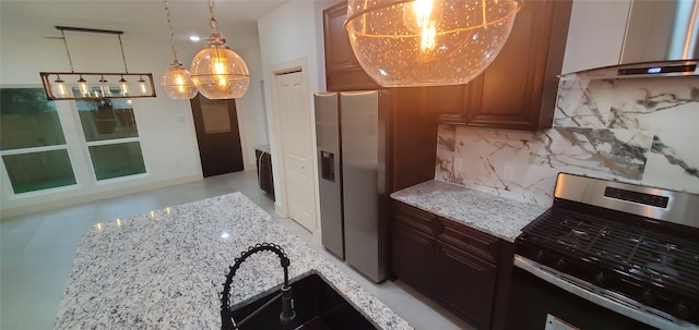 kitchen featuring appliances with stainless steel finishes, backsplash, light stone counters, wall chimney exhaust hood, and sink