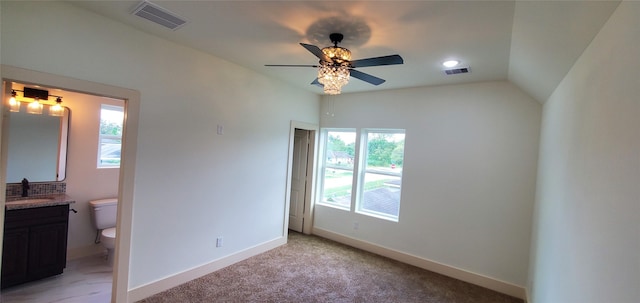 unfurnished bedroom featuring ensuite bathroom, ceiling fan, lofted ceiling, and multiple windows