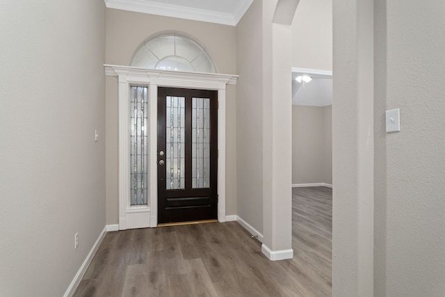 entryway with hardwood / wood-style flooring and ornamental molding