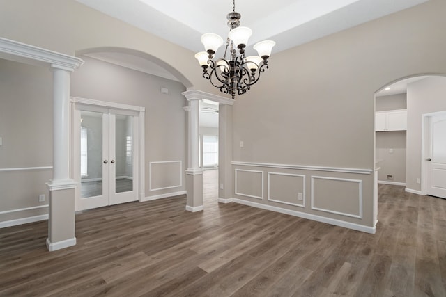 interior space featuring dark wood-type flooring, an inviting chandelier, and ornate columns