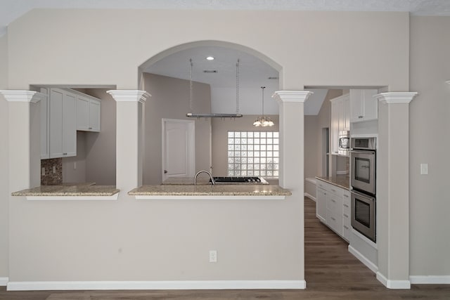 kitchen with white cabinets, light stone counters, and dark hardwood / wood-style flooring