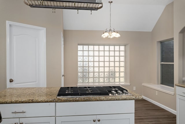 kitchen featuring pendant lighting, light stone countertops, and white cabinets