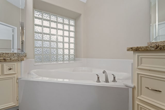 bathroom with vanity and a bath