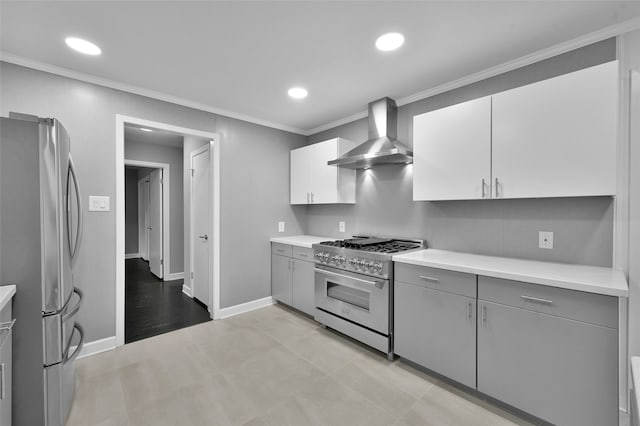 kitchen featuring wall chimney exhaust hood, appliances with stainless steel finishes, light countertops, and white cabinets