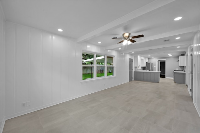 unfurnished living room featuring ceiling fan, a decorative wall, recessed lighting, visible vents, and beam ceiling