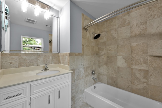 full bath featuring shower / washtub combination, a wainscoted wall, tile walls, visible vents, and vanity