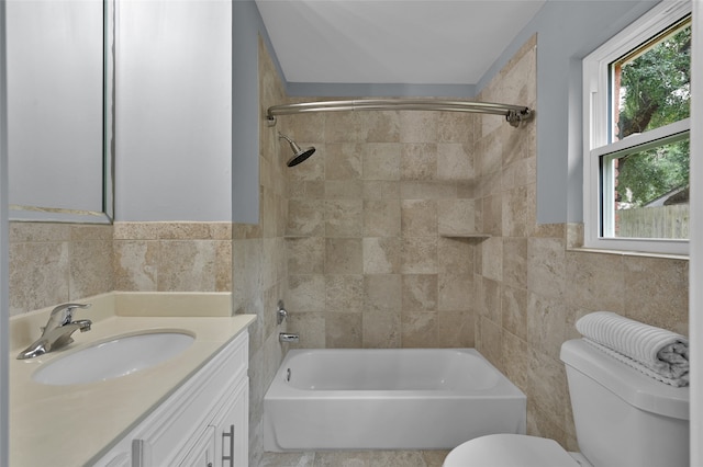 full bath with toilet, bathtub / shower combination, vanity, and tile walls