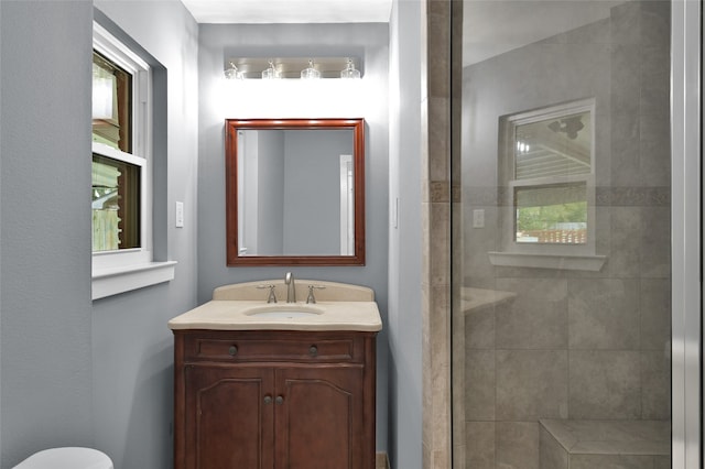 bathroom with a tile shower and vanity