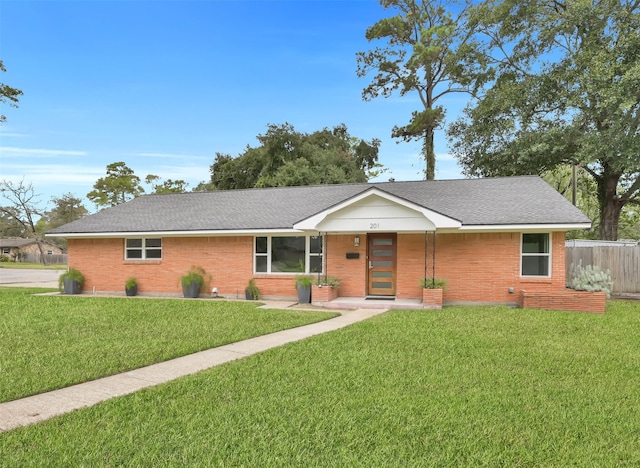 ranch-style home featuring fence, a front lawn, and brick siding