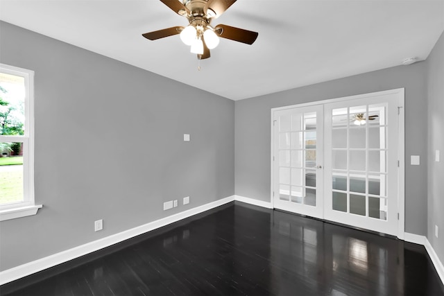 spare room featuring plenty of natural light, baseboards, ceiling fan, and wood finished floors