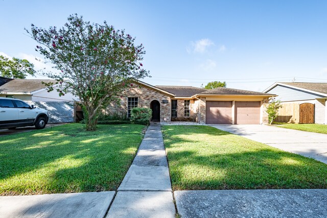 single story home with a garage and a front lawn