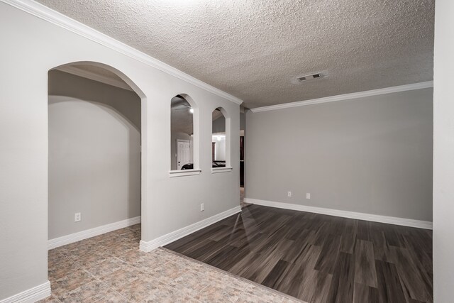 unfurnished room with ornamental molding, dark wood-type flooring, and a textured ceiling