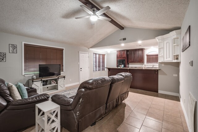 living room featuring a textured ceiling, ceiling fan, light tile patterned floors, and lofted ceiling with beams