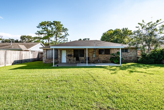 rear view of property featuring a lawn and a patio area