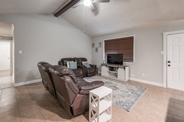 living room with ceiling fan, light tile patterned floors, lofted ceiling with beams, and a textured ceiling