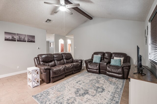 living room with a textured ceiling, ceiling fan, and vaulted ceiling with beams