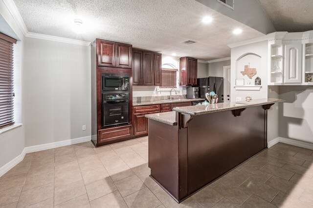 kitchen with ornamental molding, a textured ceiling, a kitchen breakfast bar, black appliances, and sink