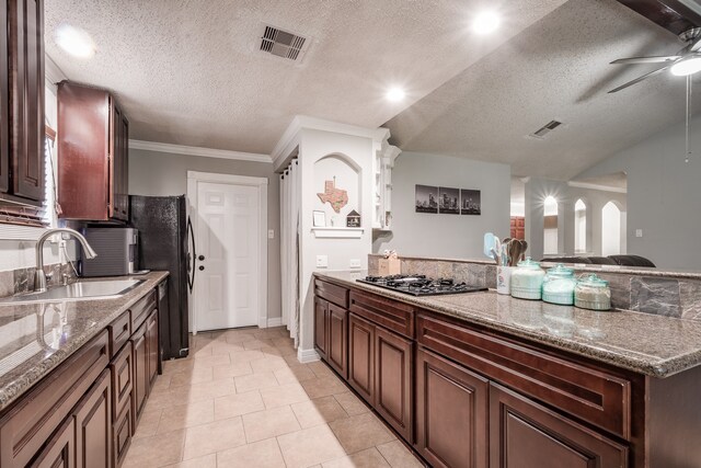 kitchen with a textured ceiling, stainless steel gas stovetop, light tile patterned floors, and ceiling fan