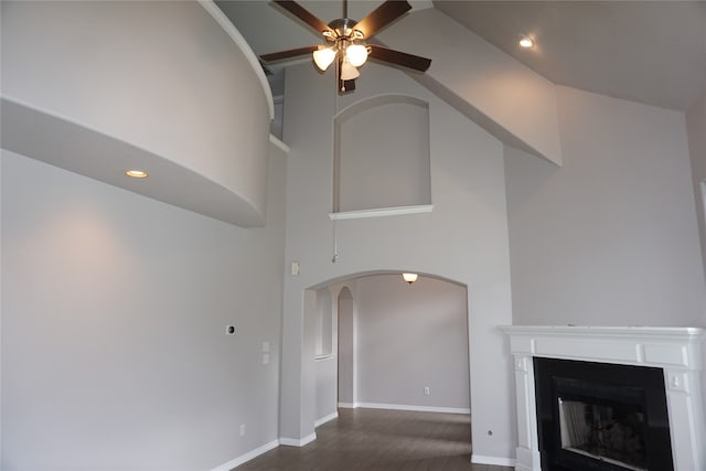 unfurnished living room featuring ceiling fan, dark wood-type flooring, and high vaulted ceiling