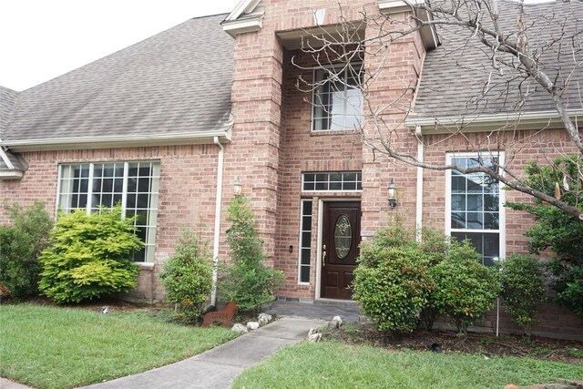 property entrance featuring a lawn