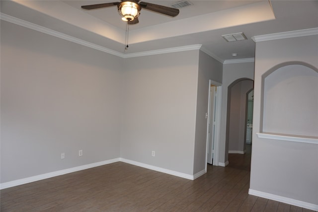 spare room featuring a raised ceiling, ornamental molding, dark hardwood / wood-style floors, and ceiling fan